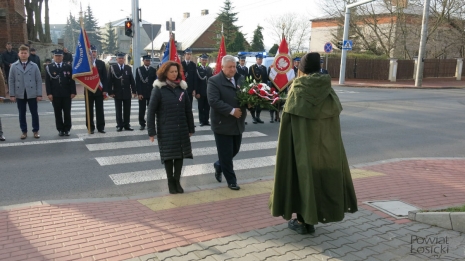 Wiceprzewodnicząca Rady U. Sadowska i Starosta Łosicki J. Kobyliński przekazują kwiaty harcerzowi pełniącemu wartę przy pomniku w tle poczty sztandarowe